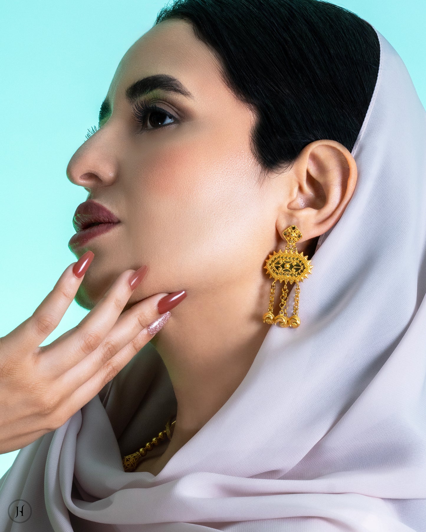 This 21K yellow gold traditional Bahraini necklace set features an oval-shaped pendant with floral filigree details and crescent moon hangings. The opera-length necklace fastens with an adjustable string and is accompanied by matching push-back chandelier earrings.
A traditional Khaleeji jewelry piece, perfect for bridal, wedding, or special occasions. This elegant Arabic design pairs beautifully with abayas and jalabiyas.