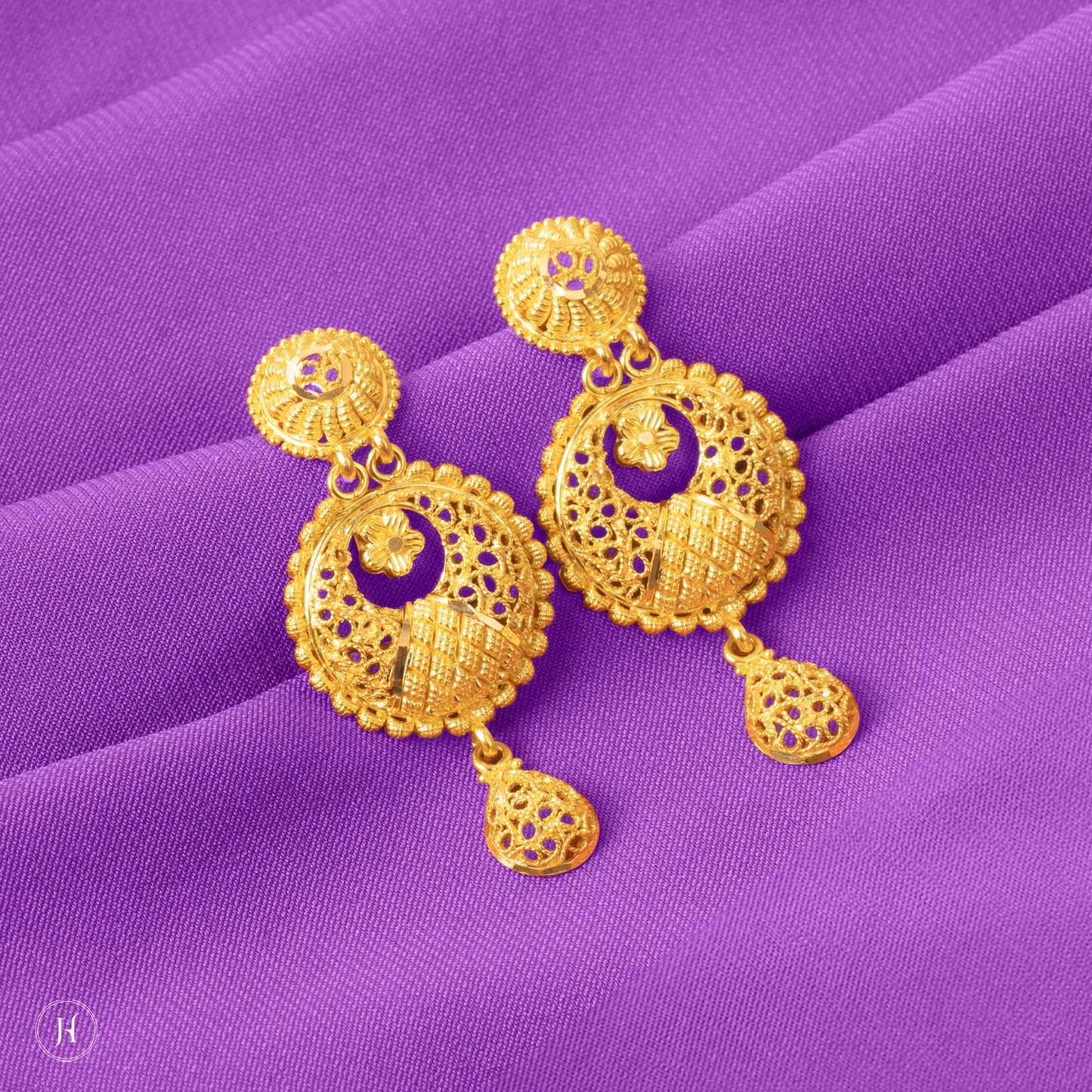 These 21K yellow gold Bahraini double-drop earrings feature a round flower motif with a small pendant drop. The earrings secure with pushback closures.
A classic Arabian piece, perfect for pairing with traditional outfits at weddings, night outs, and traditional events.
