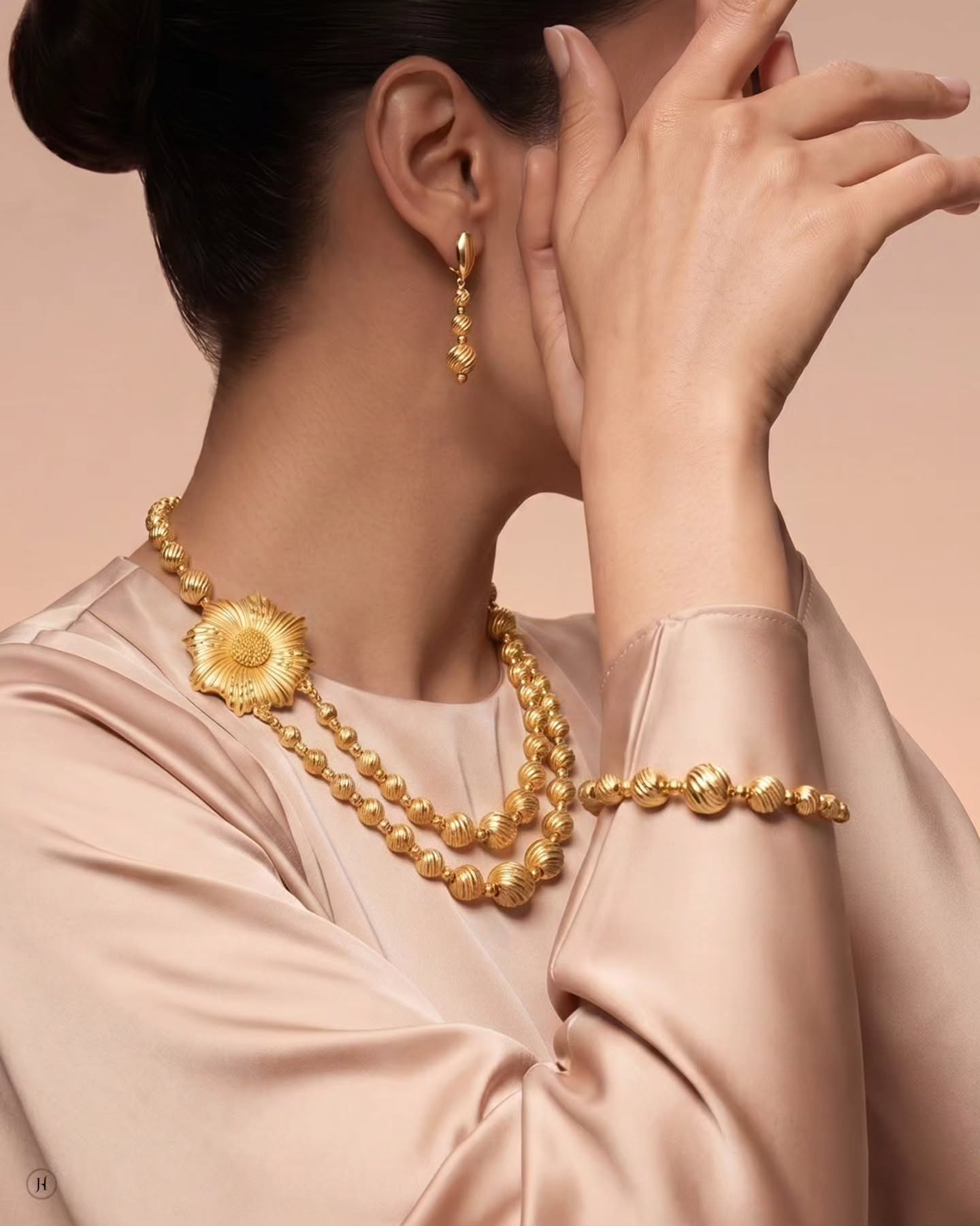 Lady wearing 21K yellow gold Bahraini diamond-cut bead necklace set with sunflower pendant, drop earrings and bracelet — Emirati and Khaleeji women's jewellery, Dubai, UAE.