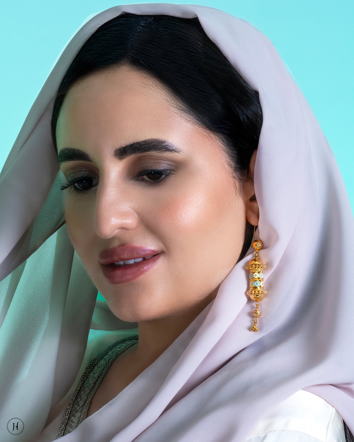 This 21K yellow gold traditional Bahraini long necklace set features a mezuzah-inspired design in mina work, adorned with bead and small flower hangings. The rope-length necklace fastens with a fish-eye clasp and is accompanied by matching drop earrings and a ring.
A traditional Khaleeji jewelry piece, perfect for bridal, wedding, or special occasions. This elegant Arabic design pairs beautifully with abayas.