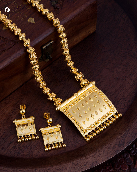 21K Yellow Gold Bahraini Square Pendant Necklace Set Discover luxury bridal jewelry with this exquisite 21K yellow gold necklace set, featuring an authentic Bahraini square pendant design. Handcrafted from pure gold, this statement piece combines traditional Middle Eastern artistry with timeless elegance, making it the perfect choice for weddings, engagements, and special occasions. The geometric square pendant showcases intricate detailing characteristic of Bahraini jewelry.