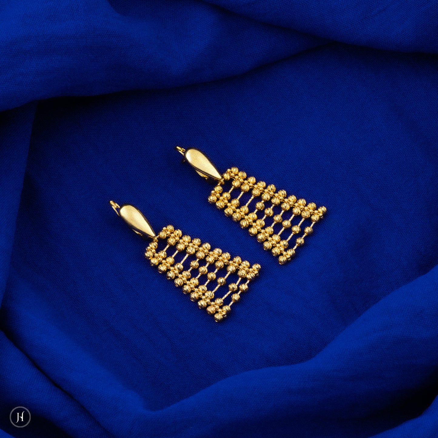 This 21K yellow gold Bahraini bridal choker set features an elegant lattice multi-beaded design adorned with delicate beads. The set includes a matching pair of drop earrings with fish hook closures, a bracelet, and a ring, completing the luxurious ensemble.
