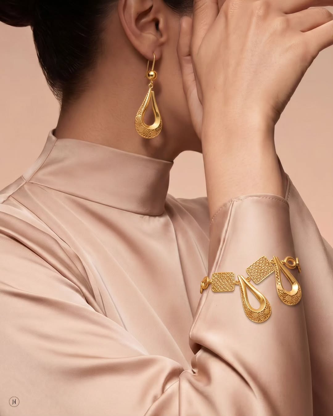 Lady wearing 21K yellow gold Bahraini filigree teardrop earrings and bracelet from the necklace set — Emirati and Khaleeji women's jewellery, Dubai, UAE.