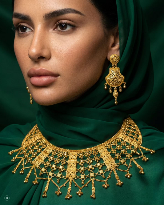 This 22-karat yellow gold set features a grand bridal bib — a wide collar of filigree lattice broken by engraved bar design and finished with a flowing fringe of bead tassels, paired with matching chandelier filigree drop earrings.

This jewellery set is crafted from 22K 916 gold, making it perfect for Bride and weddings, festive occasions, or any grand celebration.