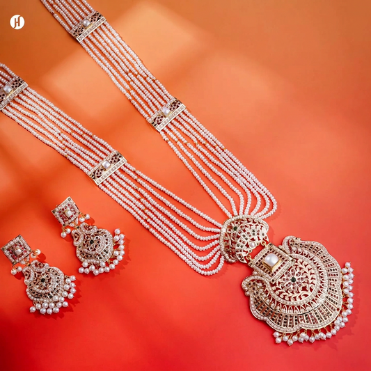 A regal 21K yellow gold Pakistani opera necklace set with lustrous freshwater pearls across flowing multi-strand chains and an pendant set with rich ruby-red and emerald-green stones | Bridal Jewellery for Women.